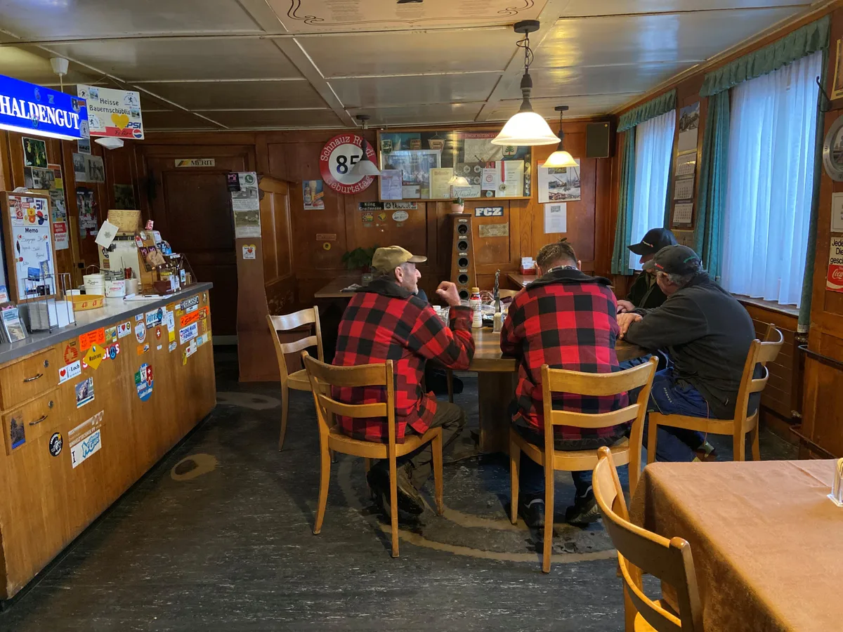 Vier Männer sitzen am Stammtisch in der Gaststube.
